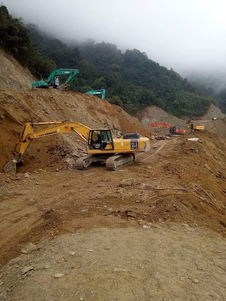 Excavator on steep forested mountainside